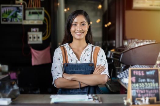 Asian women Barista smiling and using coffee machine in coffee shop counter - Working woman small business owner food and drink cafe concept