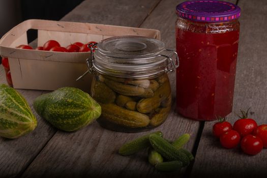 cucumber tomatoes cherry tomato jam canned corinichons on wooden background in studio