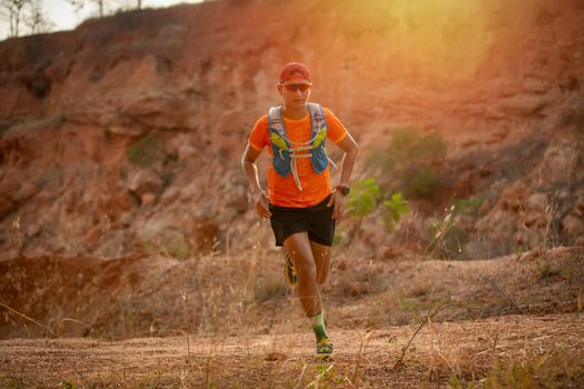 A man Runner of Trail and athlete's feet wearing sports shoes for trail running in the mountain