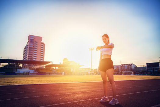 Asian woman checking her performance on watch before running