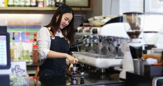 Asian women Barista smiling and using coffee machine in coffee shop counter - Working woman small business owner food and drink cafe concept