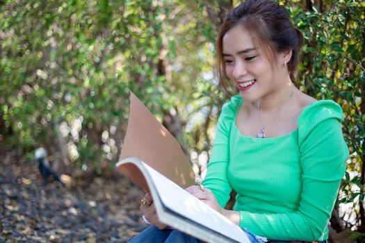 Asian women reading book and smiling and happy Relaxing in a coffee shop after working in a successful office.