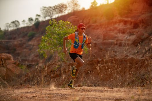 A man Runner of Trail and athlete's feet wearing sports shoes for trail running in the mountain