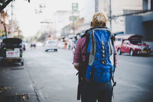 Young hipster traveling backpacker around asia. Holiday tourist concept.