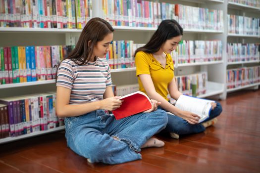 Group Asian  Students Smile and reading book and using notebook for helps to share ideas in the work and project. And also review the book before the exam