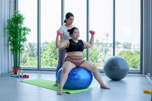 Asian Fat woman and trainer work out in the fitness class and The trainer recommends exercise for weight loss for obese women