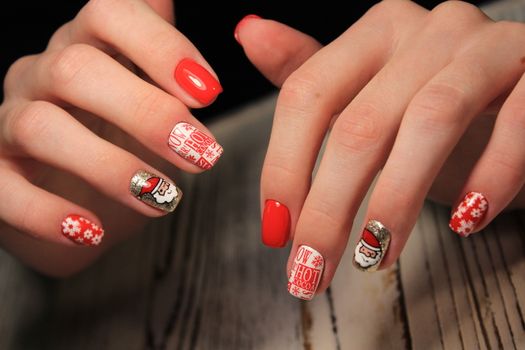 Christmas Nail art manicure. Winter Holiday style bright Manicure with gems Christmas tree and snowflakes. Bottle of Nail Polish.