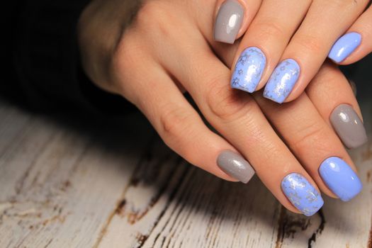 Christmas Nail art manicure. Winter Holiday style bright Manicure with gems Christmas tree and snowflakes. Bottle of Nail Polish.