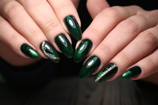 Closeup photo of a beautiful female hands with elegant manicure and diamond rings.