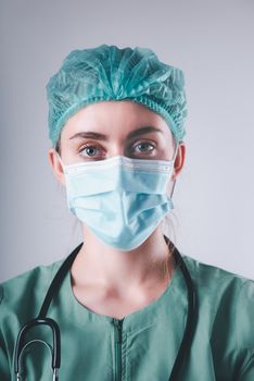 Female Doctor in Protective Mask and Medical Cap on Isolated Background, Closeup Portrait of Medicine Surgeon Doctor Wearing Medical Mask With Stethoscope. Clinical Health Care/Doctors Occupation