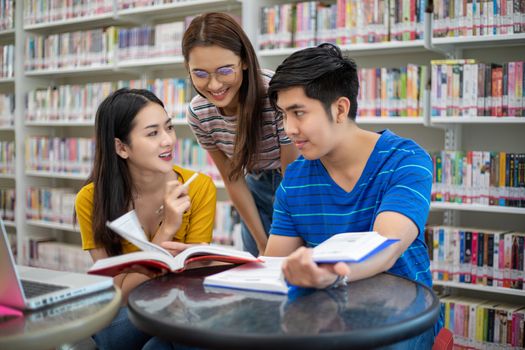 Group Asian  Students Smile and reading book and using notebook for helps to share ideas in the work and project. And also review the book before the exam