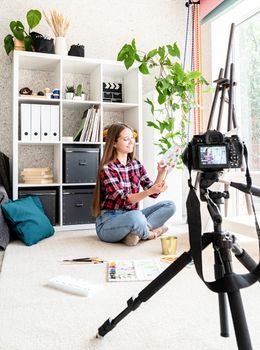 Young artist woman blogger making a video for her blog on art painting a picture