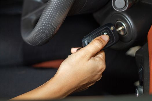 Woman 's hands hold the key for starting the car