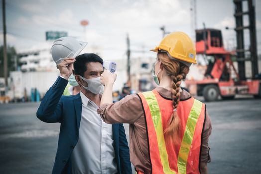 Coronavirus Covid-19 Disease Epidemic Crisis Situation, Construction Worker Having Fever Body Scan by Thermometer Scanning at Construction Site. Corona-Virus Covid19 Prevention of New Normal Concept