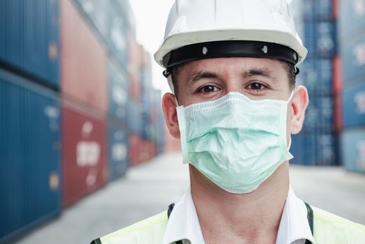 Transport Engineer Man Wearing Medical Face Mask for Prevention Coronavirus Epidemic Situation in Containers Logistic Shipping Yard. Transportation and Logistics after Coronavirus Covid-19 New Normal