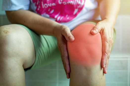 Old Asian women to knee injury on white background,