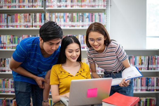 Group Asian  Students Smile and reading book and using notebook for helps to share ideas in the work and project. And also review the book before the exam