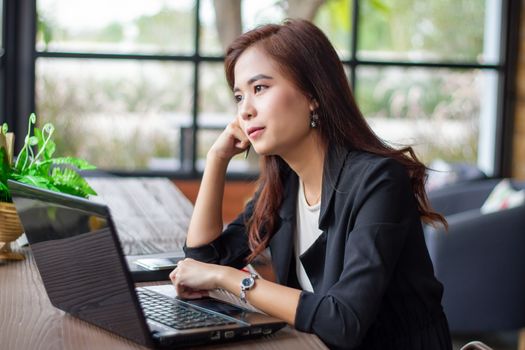 Asian businesswoman are thinking to create new jobs and are smiling and working happy