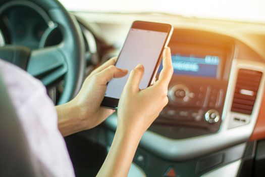 Asian women are driving cars and using a smartphone on the road.