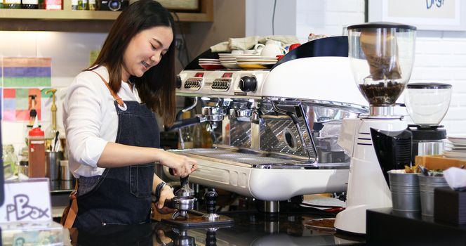 Asian women Barista smiling and using coffee machine in coffee shop counter - Working woman small business owner food and drink cafe concept