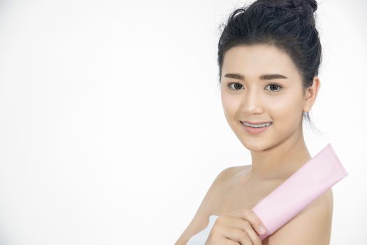 A beautiful woman asian using a skin care product, moisturizer or lotion taking care of her dry complexion. Moisturizing cream in female hands .