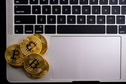 Golden coins with bitcoin symbol on computer.