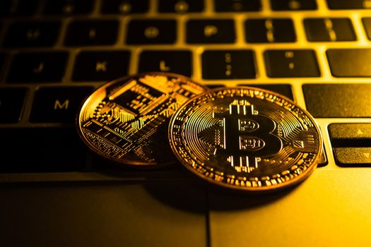 Golden coins with bitcoin symbol on computer.