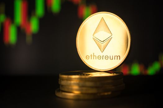 Stack of golden coins with ethereum symbol with stock graph background.