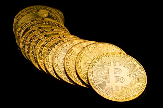 Golden coins with bitcoin symbol on a black background.