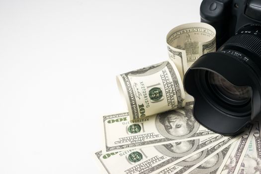 A black digital camera on banknotes with white background.