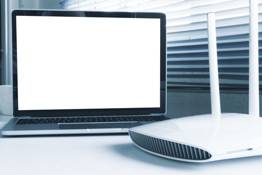 Blank screen laptop computer and router device on the table