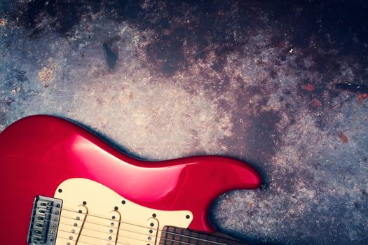 A red electric guitar on a grunge background.