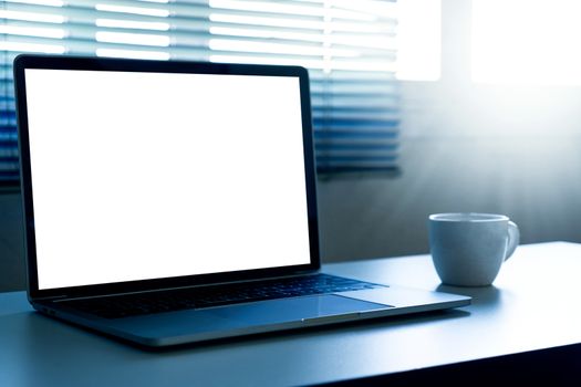 Blank screen laptop computer and a cup of coffee on the table