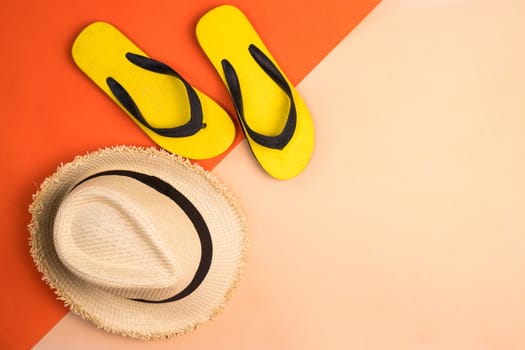 Beach hat and rubber slippers on colors background.