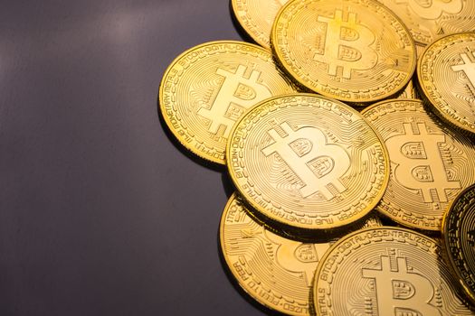 Golden coins with bitcoin symbol on a black background.