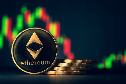 Stack of golden coins with ethereum symbol with stock graph background.