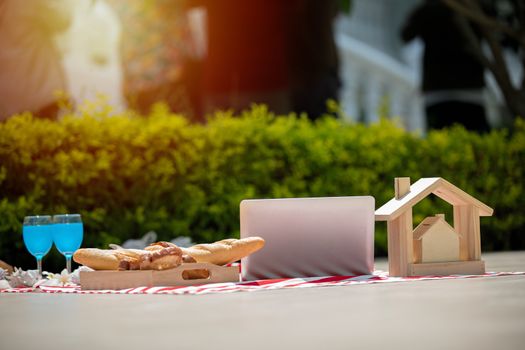 Picnic basket with food and drink on blanket. Picnic lunch outdoor in a field on sunny day with bread