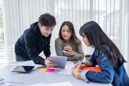 Group Students Smile and have fun and using tablet It also helps to share ideas in the work and project. And also review the book before the exam