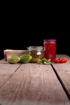 cucumber tomatoes cherry tomato jam canned corinichons on wooden background in studio