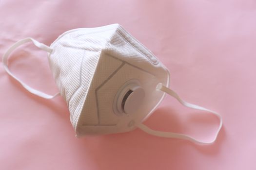 An N95 mask against a pink background to show the concept of infection control, novel coronavirus (2019-nCoV) outbreak and global health emergency