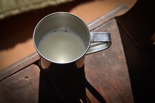 Top view of fresh raw cow milk in a tin cup, a common traditional drink in Nepal