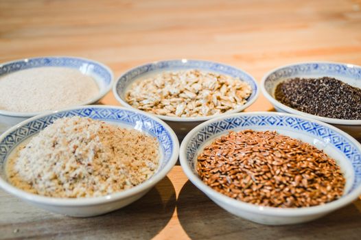 Various grains of oats, millet and ground nuts in plates for baking gluten-free bread