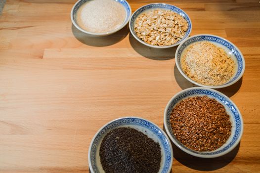 Various grains of oats, millet and ground nuts in plates for baking gluten-free bread