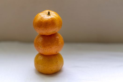 Three tangerines stacked on top of each other