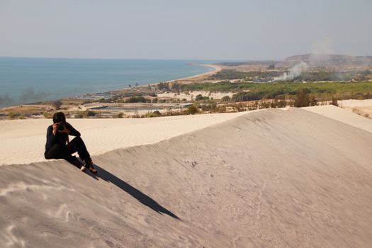 A photographer taking photos of the desert sand dunes in Phan Ri Cua, Vietnam