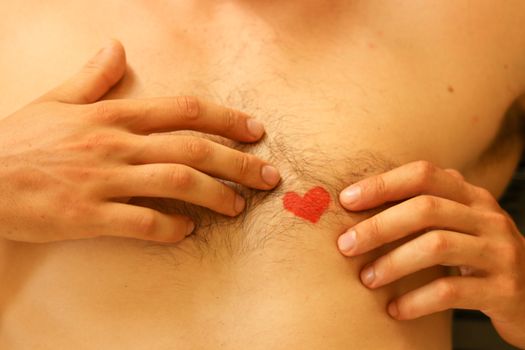 Close up of a heart drawing on a naked male chest showing the concept of vulnerability, falling inlove and gender