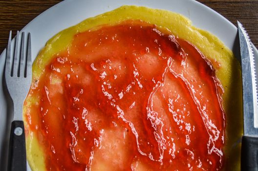 Close up of pancake smeared with strawberry jam