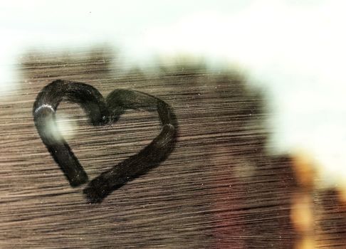 Conceptual photo of a heart shape in the window to show concept of social distancing and isolation to prevent the spread of covid-19 pandemic
