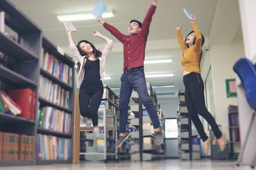 Group of student jumping in the library seem so happy.