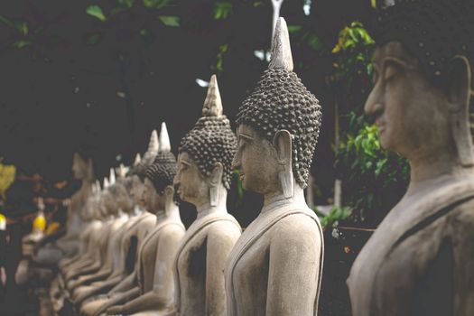 Buddha stone statues in a row at the famous Ayutthaya Historical Park which is a popular tourist destination to experience thai culture, religion and history